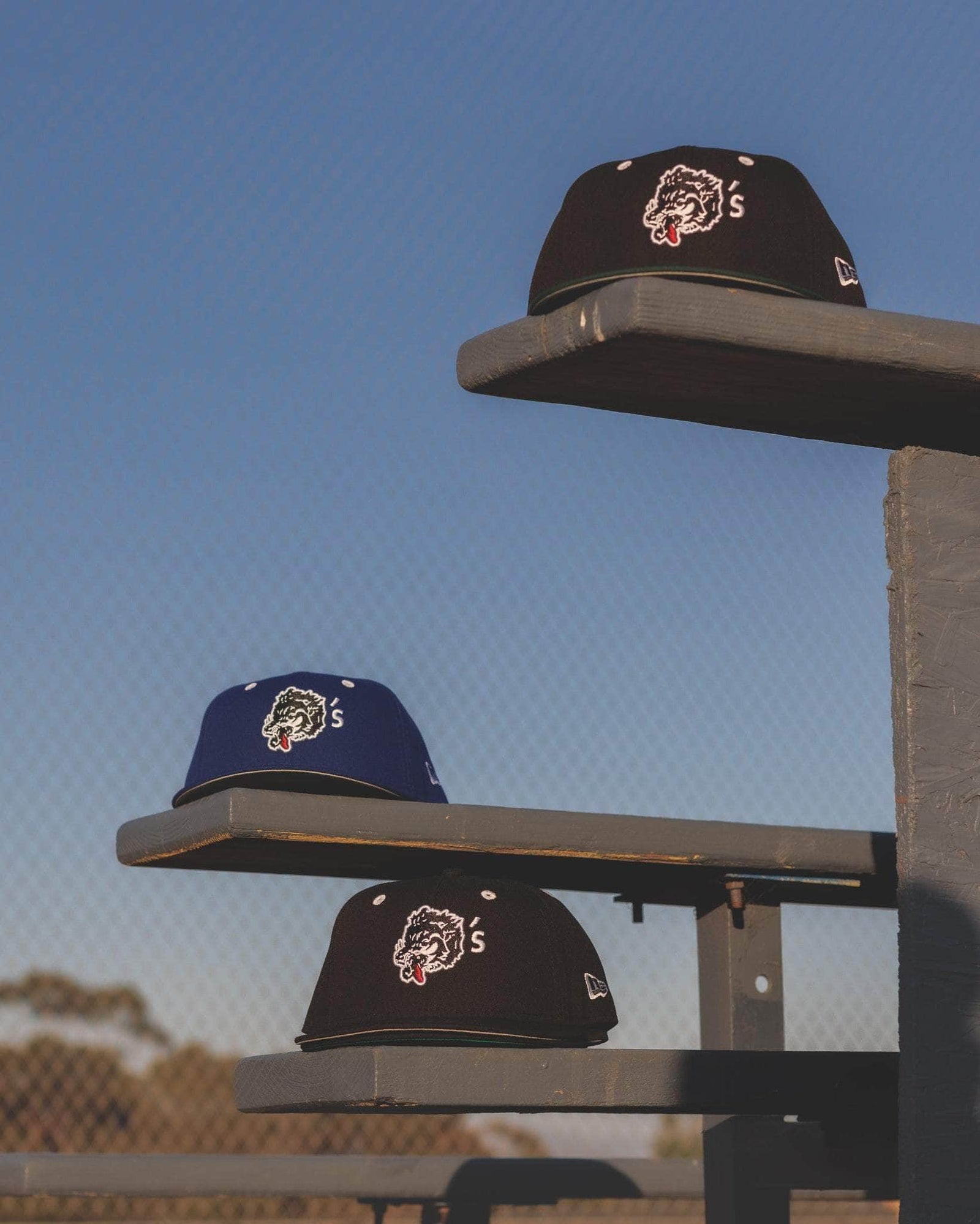 Wolf’s Head x New Era 9FIFTY snapback hats and 59FIFTY Fitted hats on bleachers– premium streetwear headwear with classic fits- Designed in California