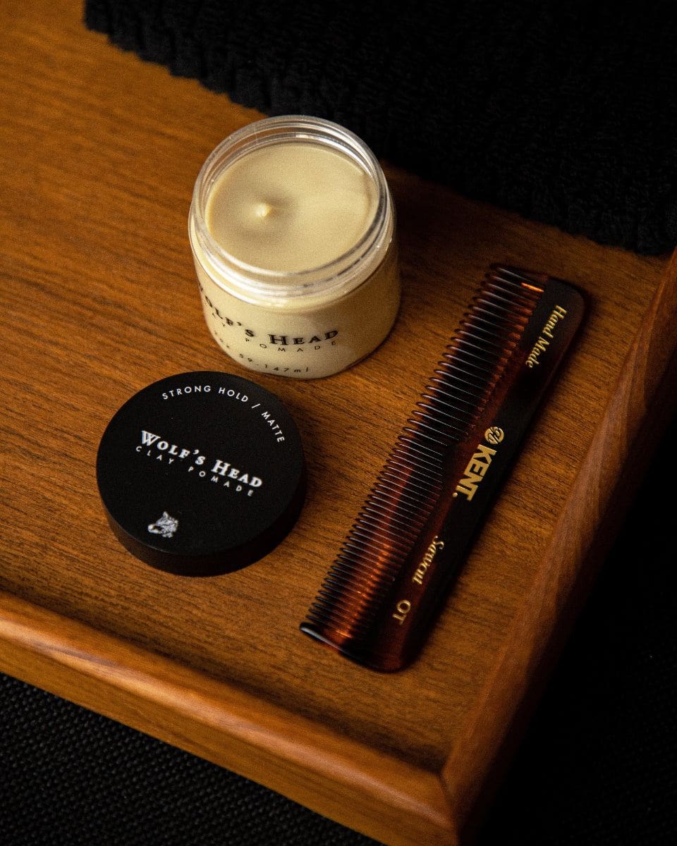 Wolf’s Head Clay Pomade with open lid and Kent pocket comb – strong hold matte clay grooming duo on teak wood