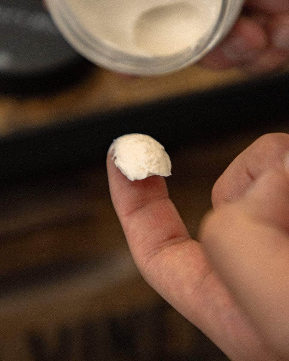 Wolf’s Head ream Pomade scoop on fingertip – medium hold, matte finish grooming product made in California