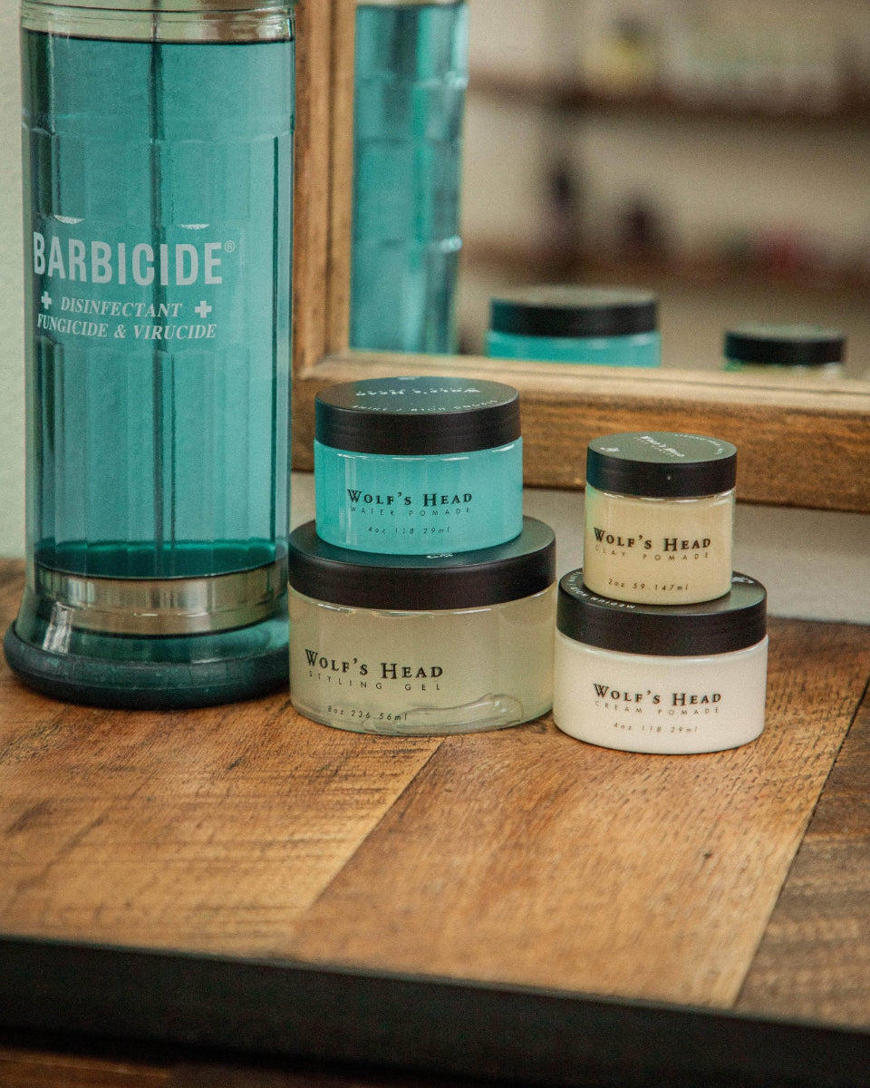 Wolf’s Head Pomades on barber station beside Barbicide – barbershop-tested strong hold , matte and shine finish hair products