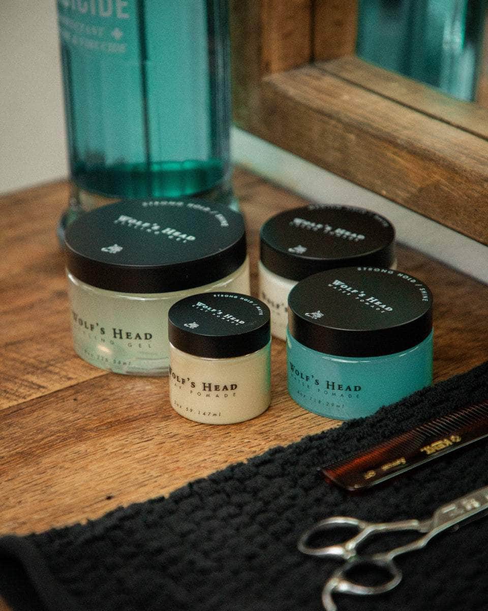 Wolf’s Head Pomades on barber station beside Barbicide, Kent comb and scissors – barbershop tested,  strong hold, matte and shine finish grooming products