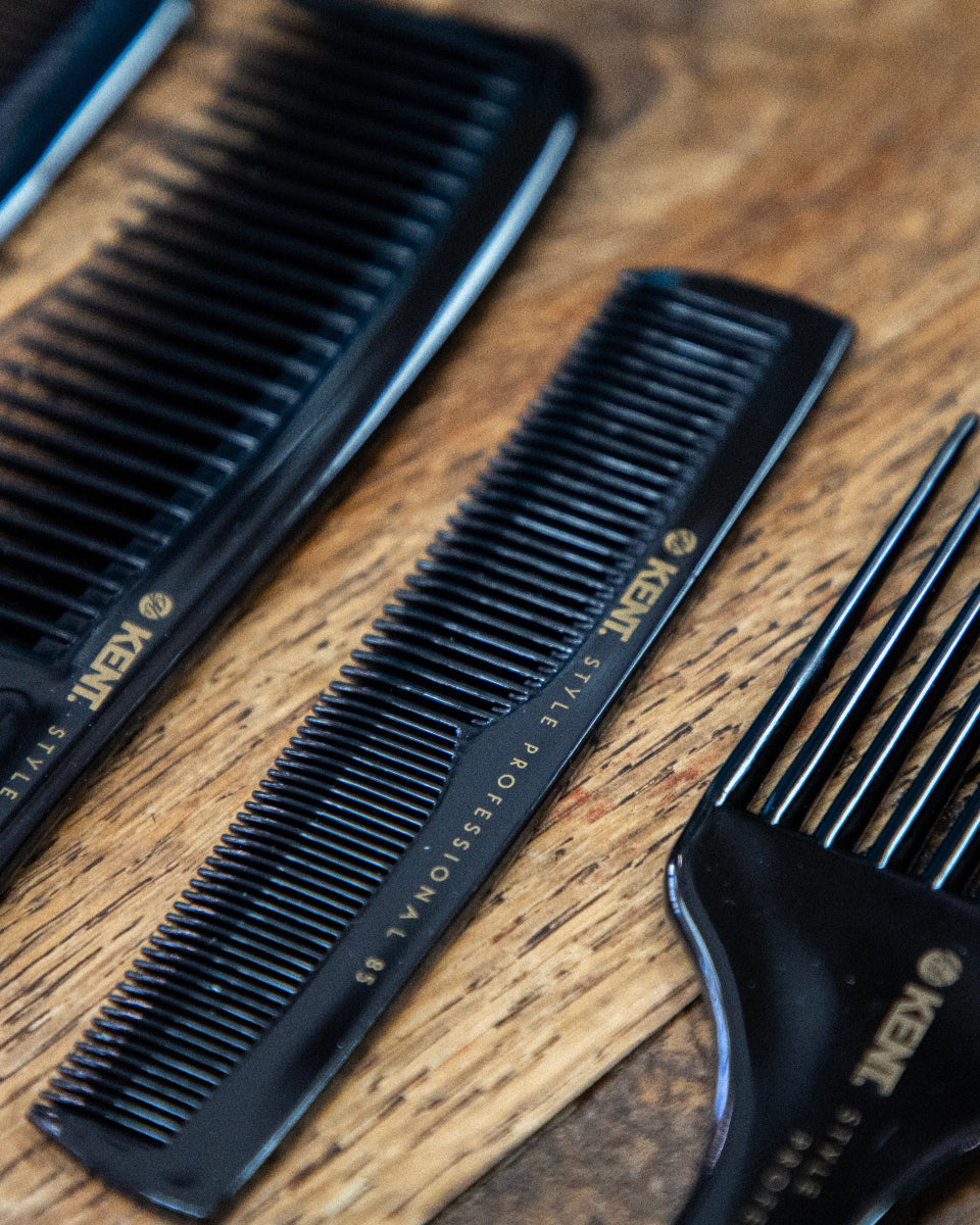 Set of 3 black Kent professional hair combs neatly arranged on a barber station—premium-grade tools trusted for precision styling in barbershop environments.