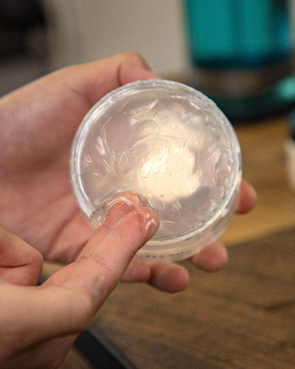 Wolf’s Head How to use Styling Gel Pomade - Jar in hand and gel on fingers. Strong hold, high shine, Barbershop tested water-based hair product made in California