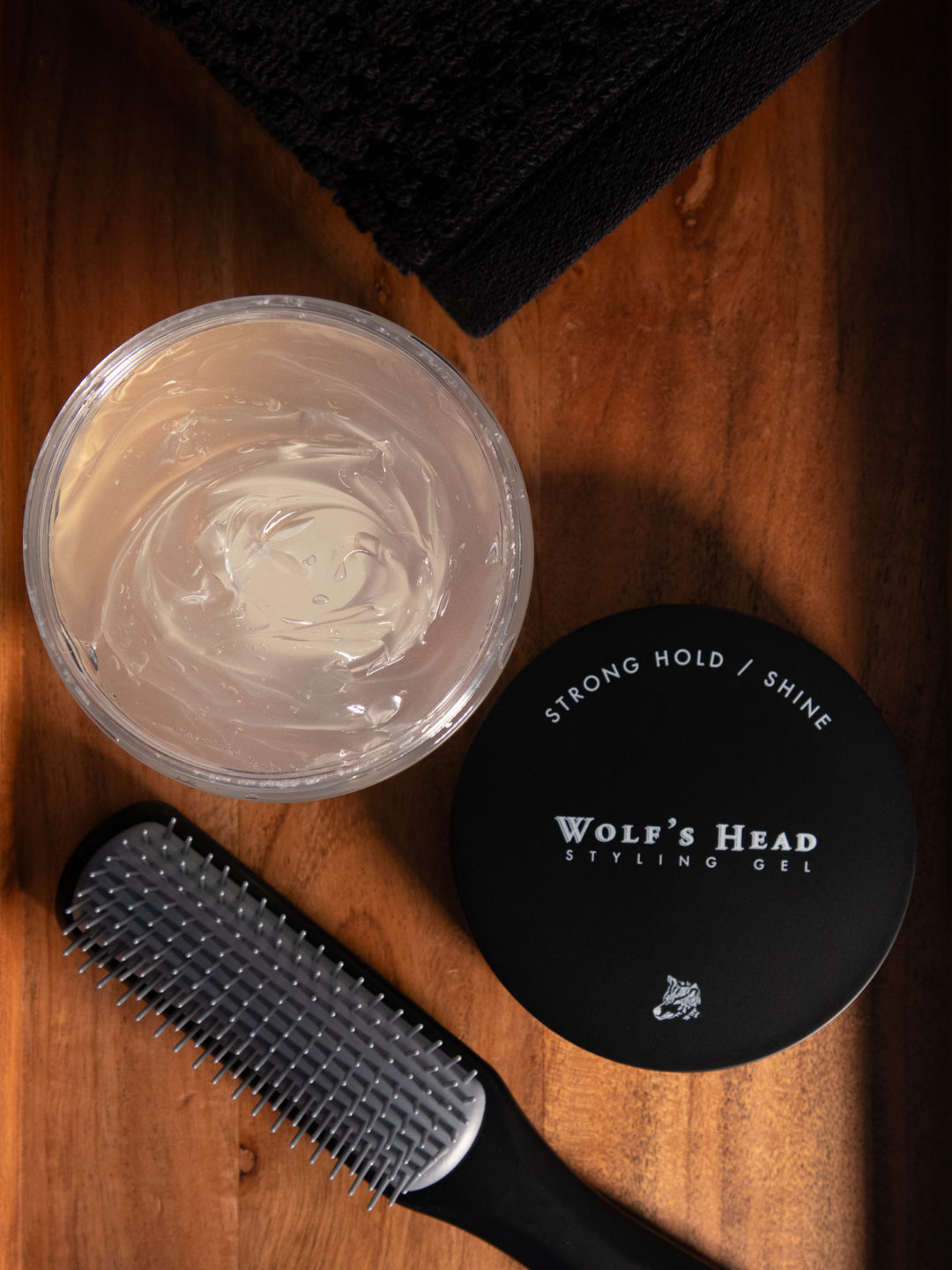 Open jar of Wolf’s Head Styling Gel Pomade with lid beside it and a Kent Comb—firm hold, high-shine gel pomade built for structured styles and long-lasting control. Clean finish, bold scent.