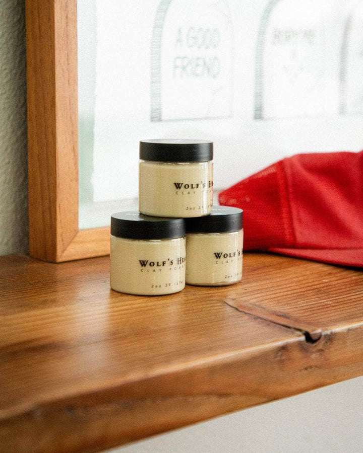 Wolf’s Head Clay Pomades displayed on wooden shelf – strong hold matte finish - professional-grade grooming product trusted by California barbers
