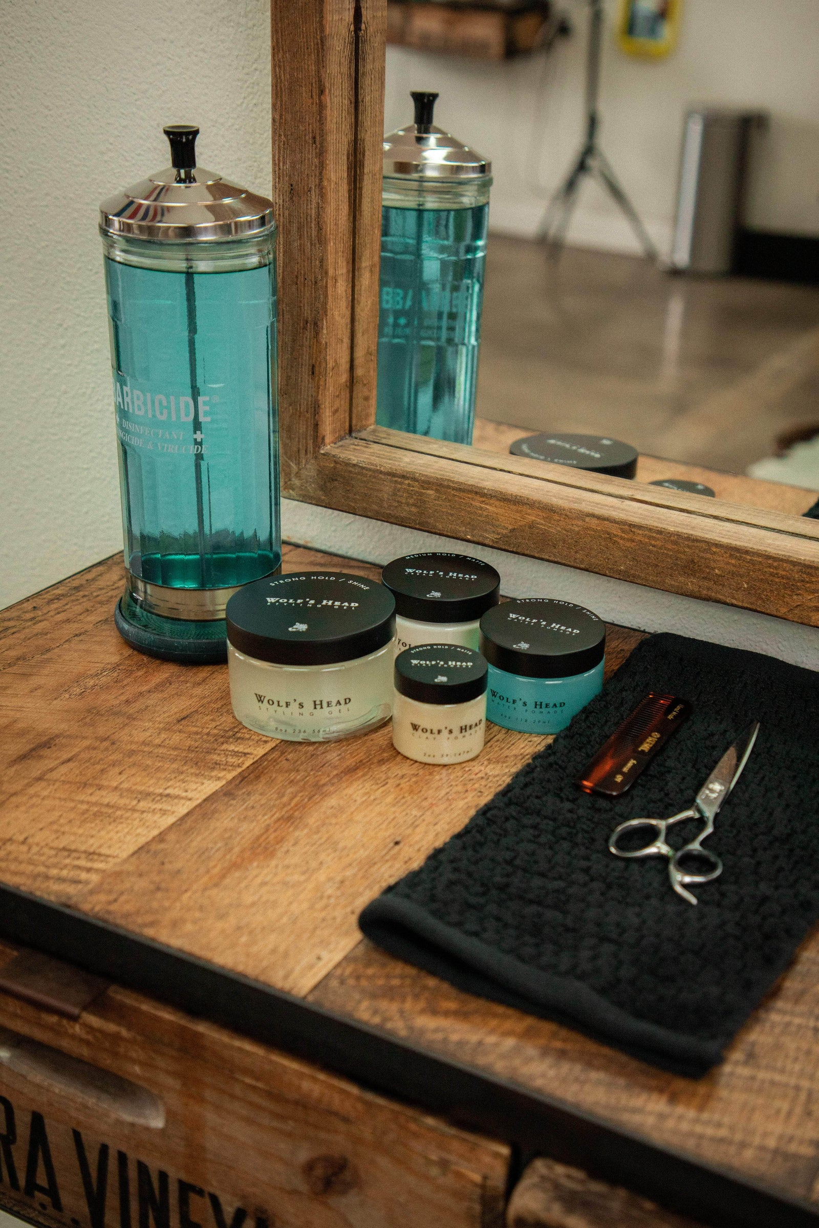 Hair care products on a wooden counter with a mirror in the background