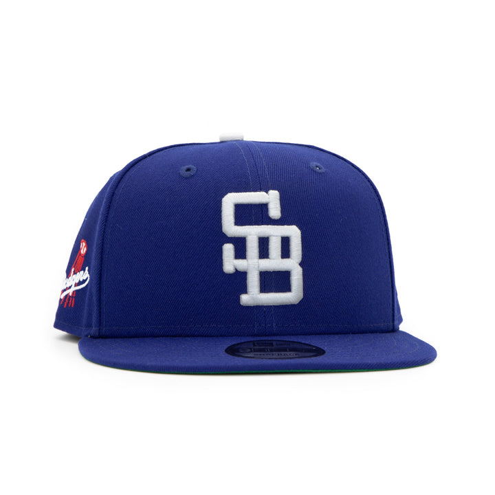 Santa Barbara Dodgers x New Era Dodger Blue 9FIFTY Snapback Hat – Quality Headwear & Classic Streetwear Baseball Cap. Available at Wolf's Head. Front Right